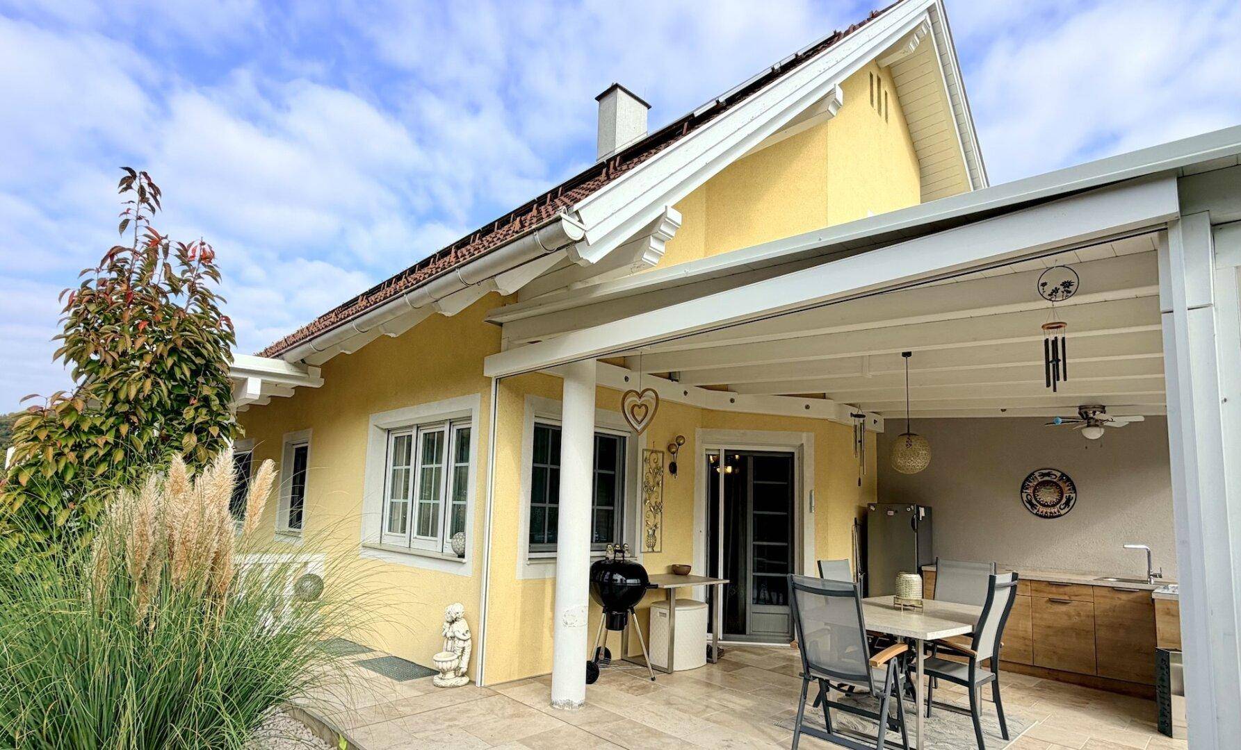 Überdachte Terrasse mit Außenküche, Grillbereich und Essplatz im Freien am Haus.