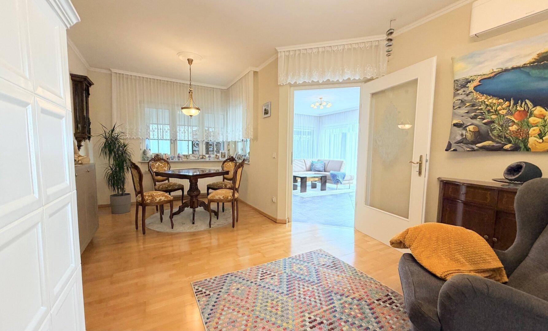 Gemütlicher Essbereich mit Holzboden und Zugang zum angrenzenden Wohnzimmer durch Glastüren.