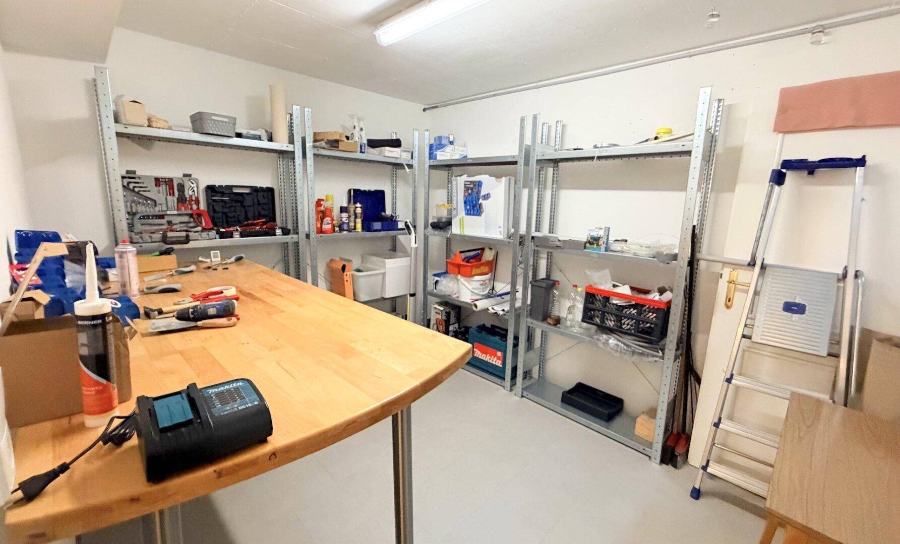 Geräumiger Hobbyraum oder Werkstatt mit Regalen und Arbeitsfläche für Heimwerker.