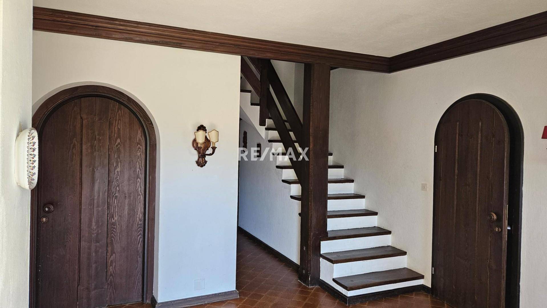 Eingangsbereich mit Holztüren, Treppe und rustikalen Holzelementen.