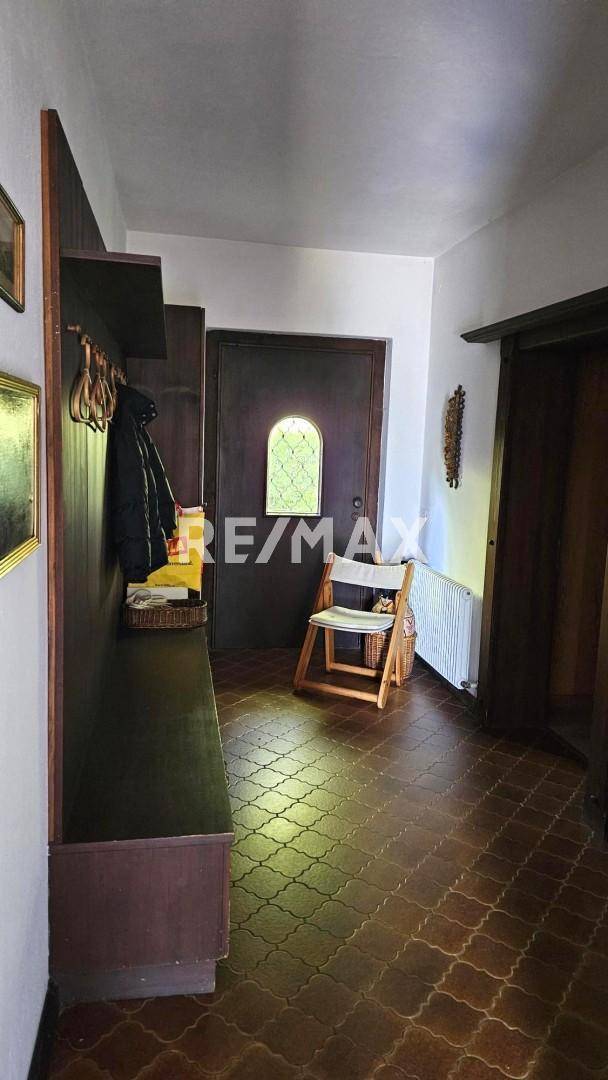 Flur mit Garderobe, Holzboden und einer rustikalen Eingangstür mit Buntglasfenster.