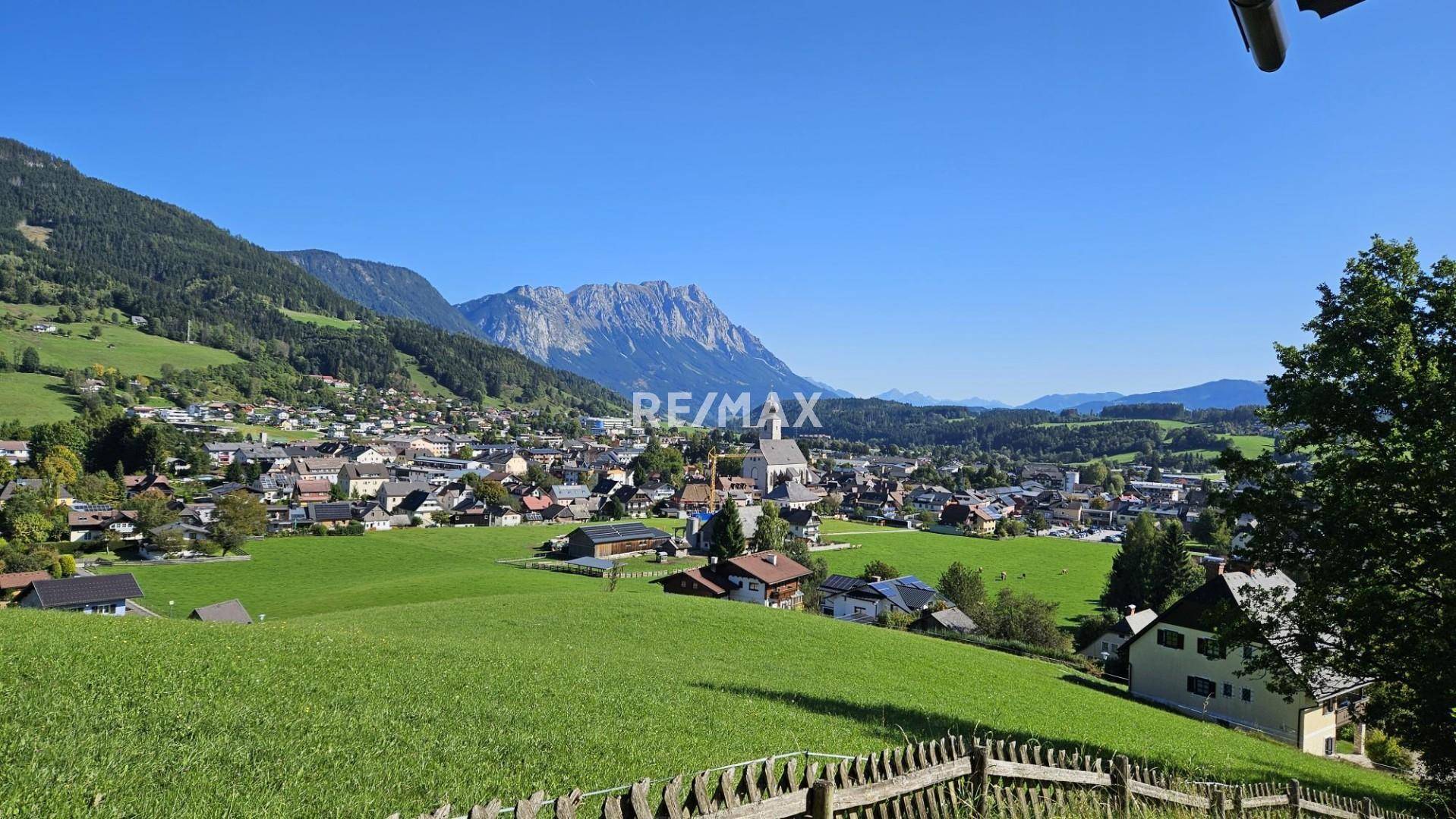 Weitläufiger Blick auf ein charmantes Dorf, eingebettet in eine idyllische Berglandschaft.