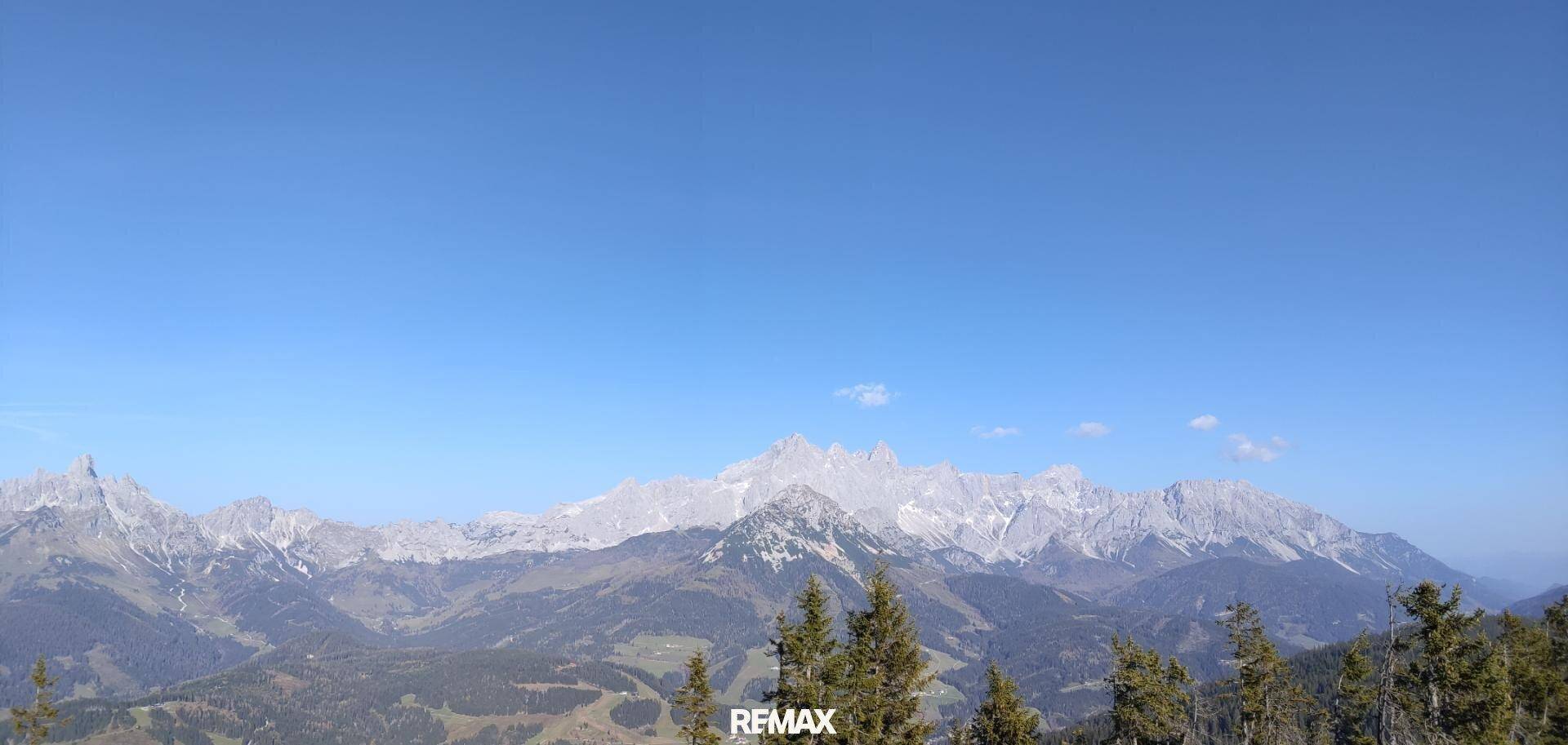 Weitläufiger Panoramablick auf eine beeindruckende Bergkette unter klarem Himmel.