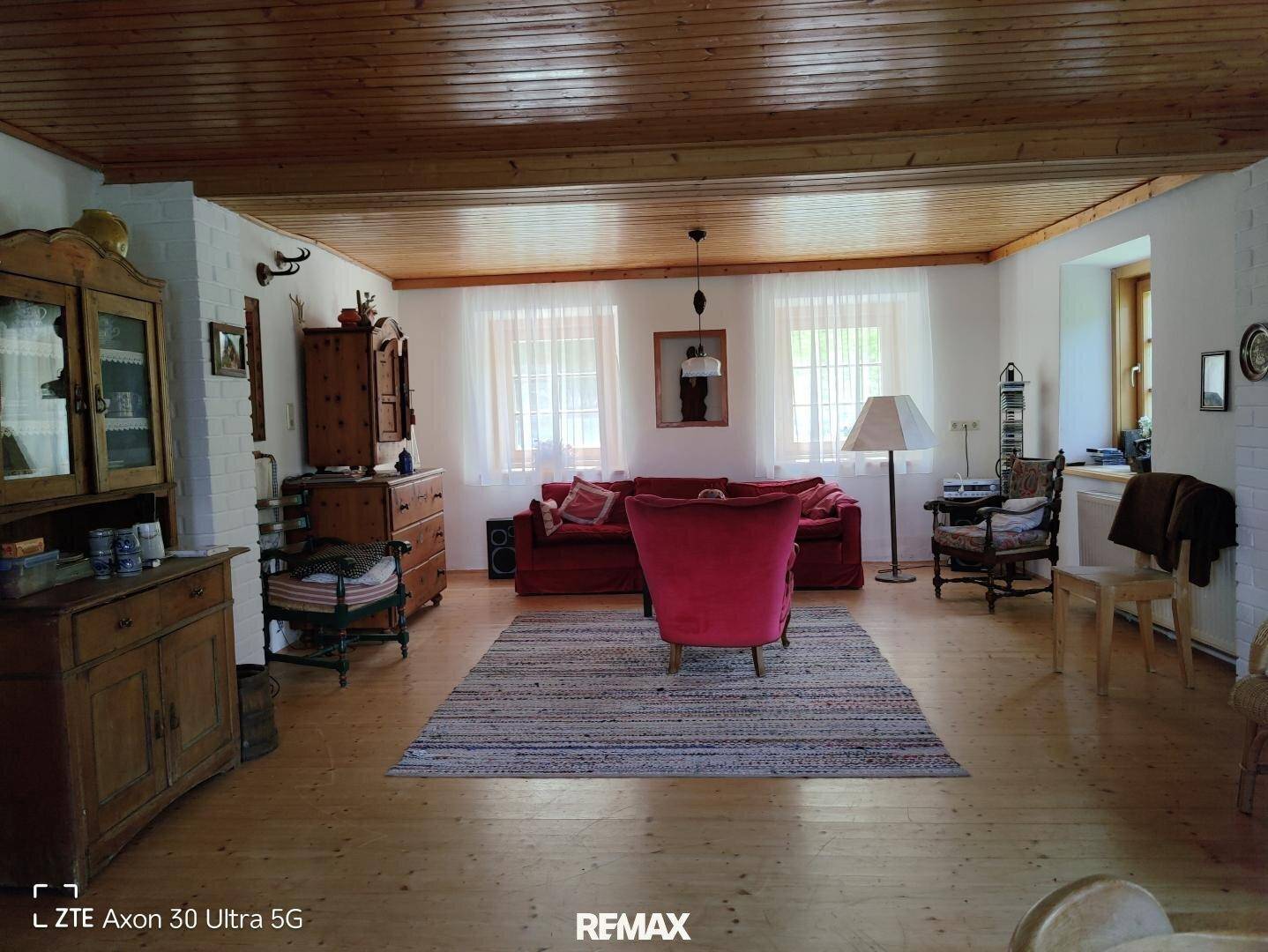 Geräumiges Wohnzimmer im Landhausstil mit Holzboden und gemütlichen Möbeln.