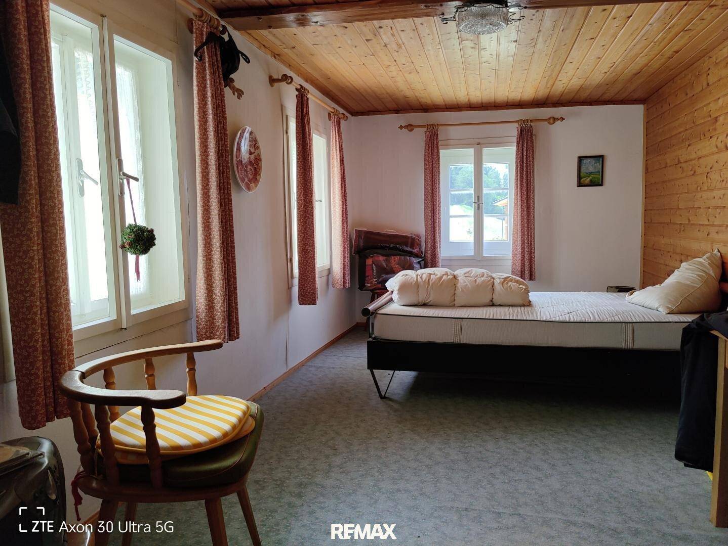 Schlafzimmer mit Holzwänden, Holzboden und einem Einzelbett.