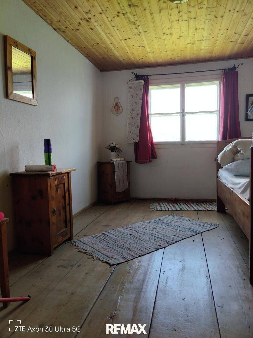 Schlafzimmer mit Holzboden, Holzdecke und traditionellen Holzmöbeln.