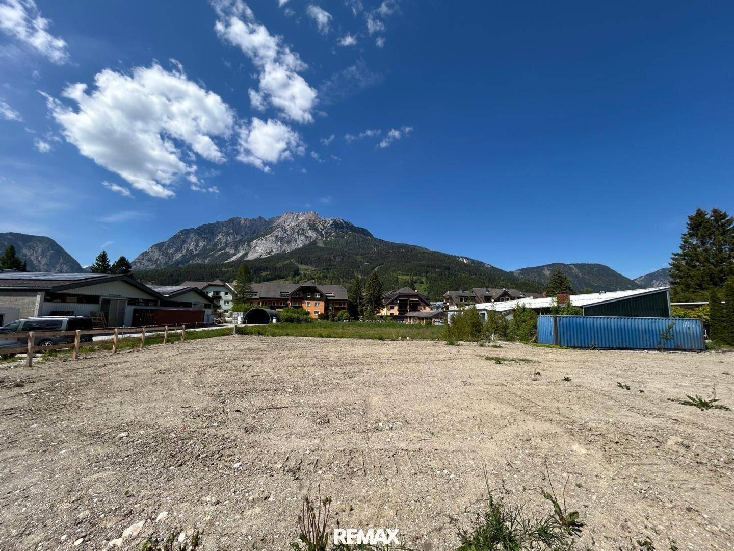Weitläufiges Baugrundstück mit Blick auf die majestätischen Berge unter blauem Himmel.