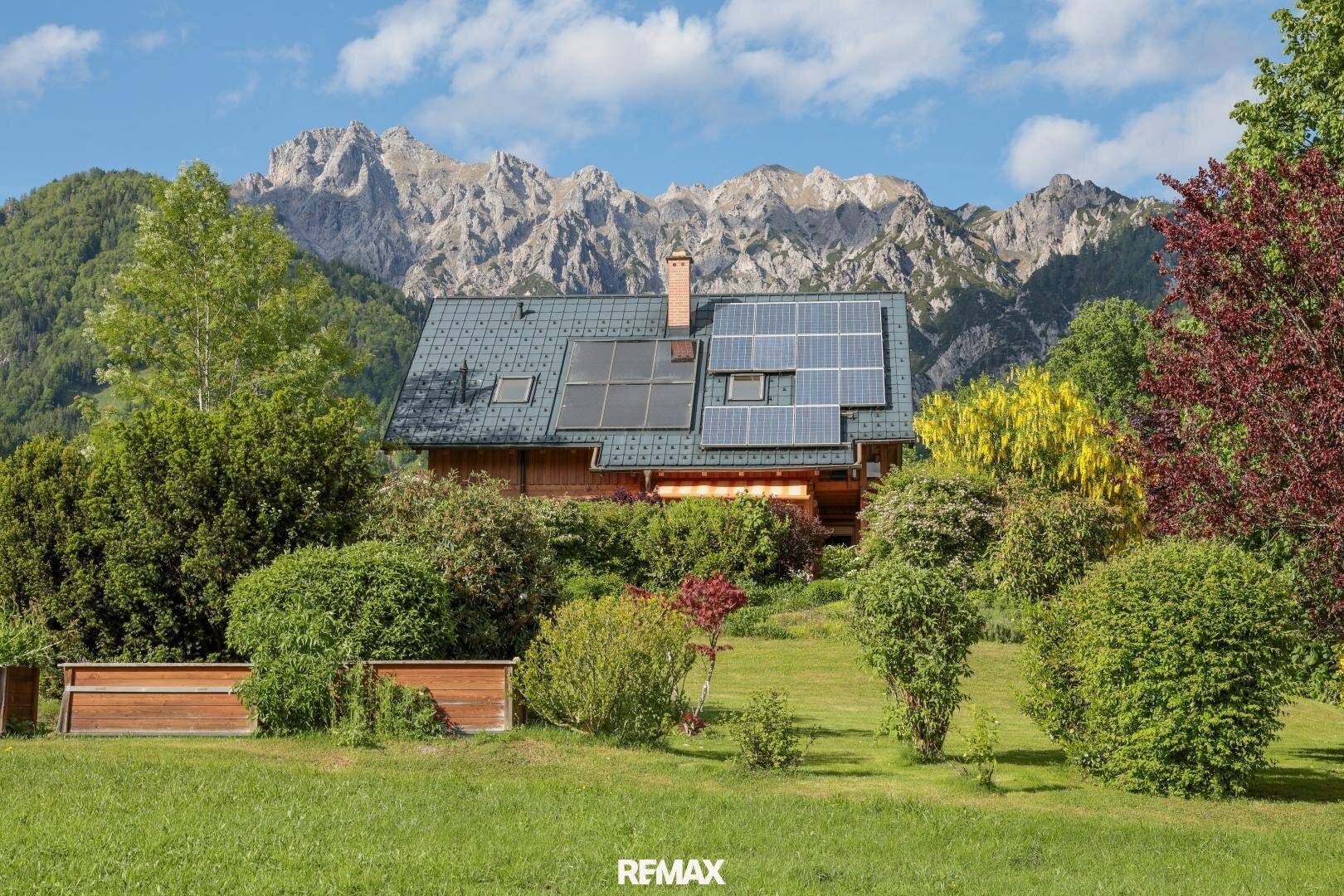 Charmantes Holzhaus mit Solaranlage auf dem Dach und beeindruckendem Bergblick.