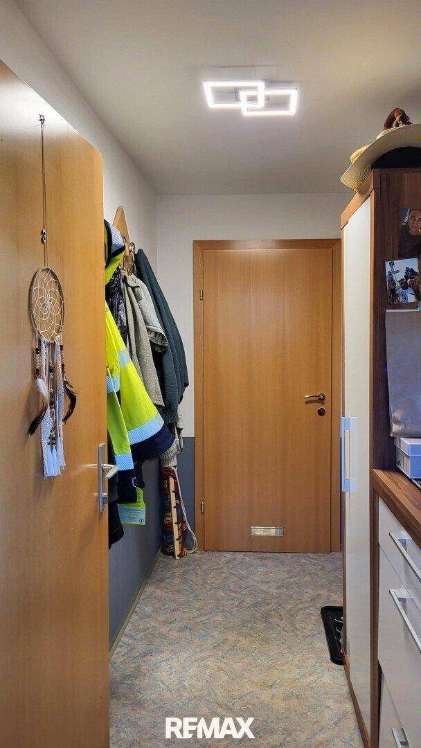 Eingangsbereich mit Garderobe, Schrank und heller Deckenleuchte.
