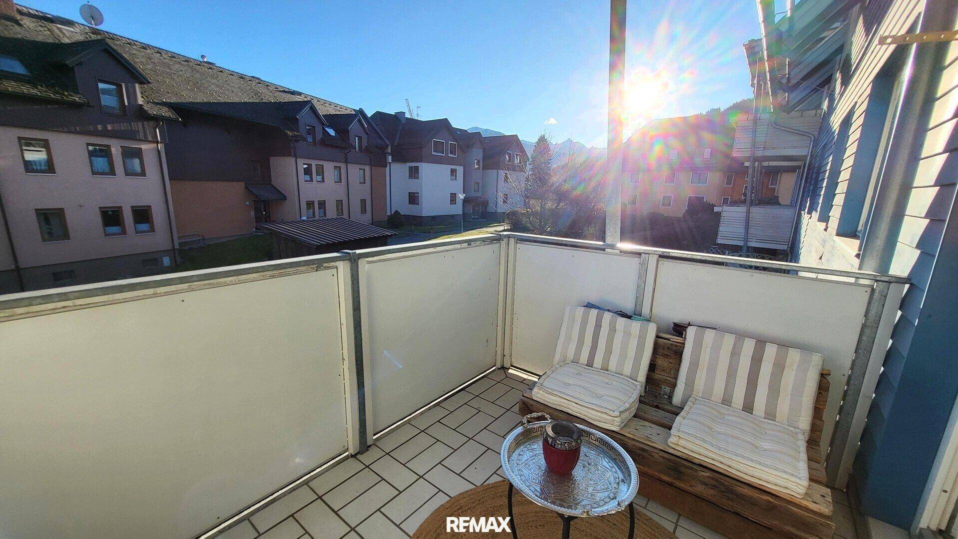Heller Balkon mit Sitzgelegenheiten und sonnigem Ausblick auf die Umgebung.
