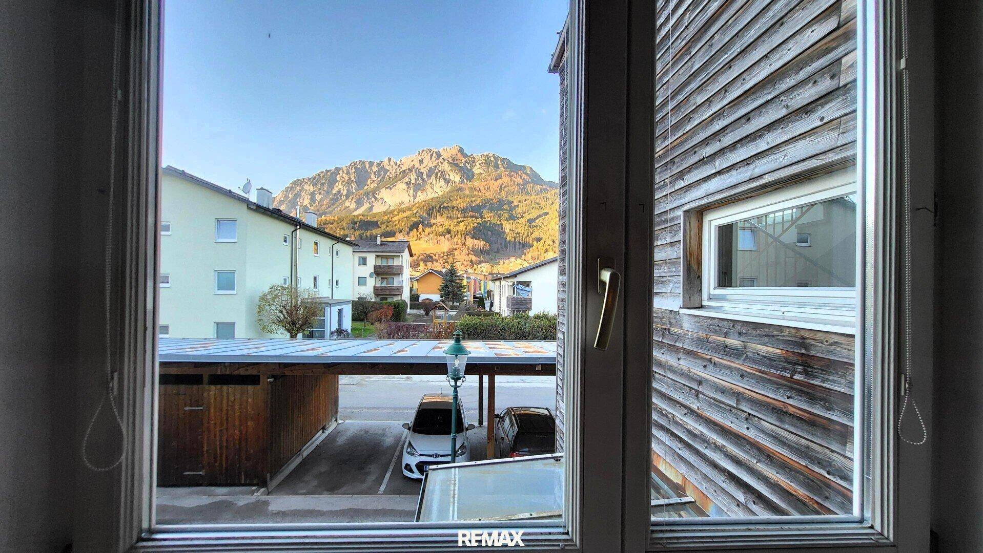Blick aus dem Fenster auf die Berge, Carports und die umliegende Bebauung.