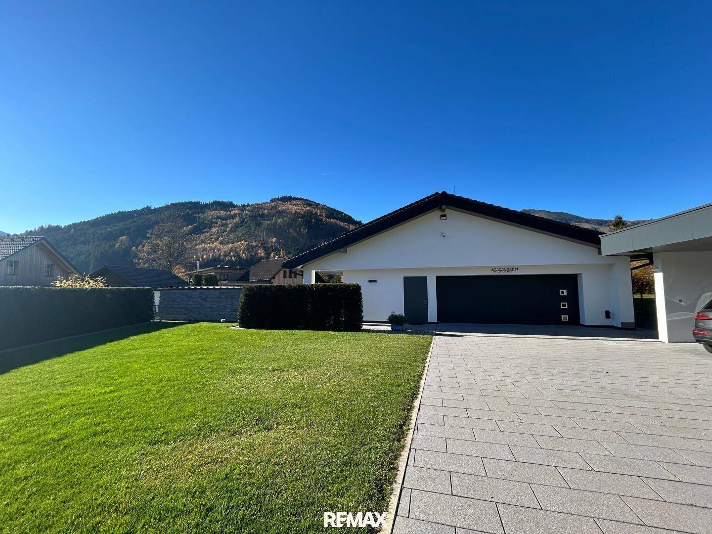 Modernes Einfamilienhaus mit gepflegtem Rasen, breiter Auffahrt und integrierter Garage.