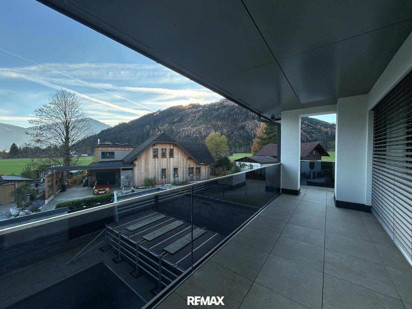 Langer Balkon mit moderner Glasbrüstung und weitem Blick auf die umliegende Landschaft.