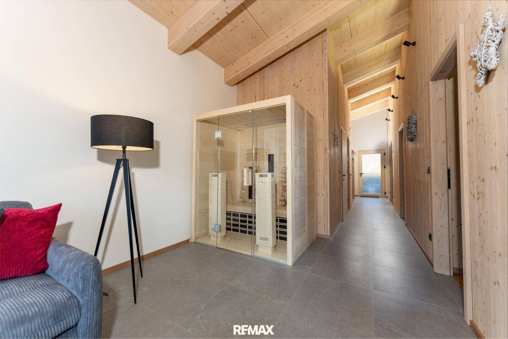 Heller Flur mit Holzwänden und -decken, neben einer modernen Sauna im Wohnbereich.