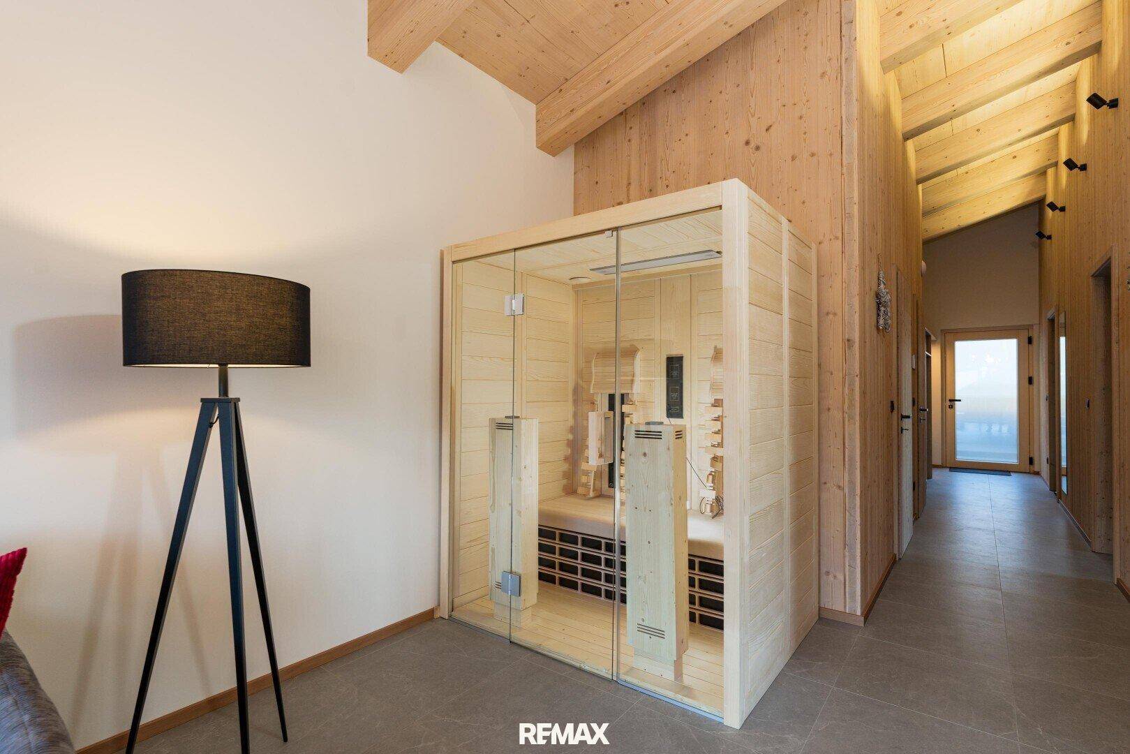 Geräumiger Flur mit Holzbalkendecke und einer modernen Sauna für Entspannung.