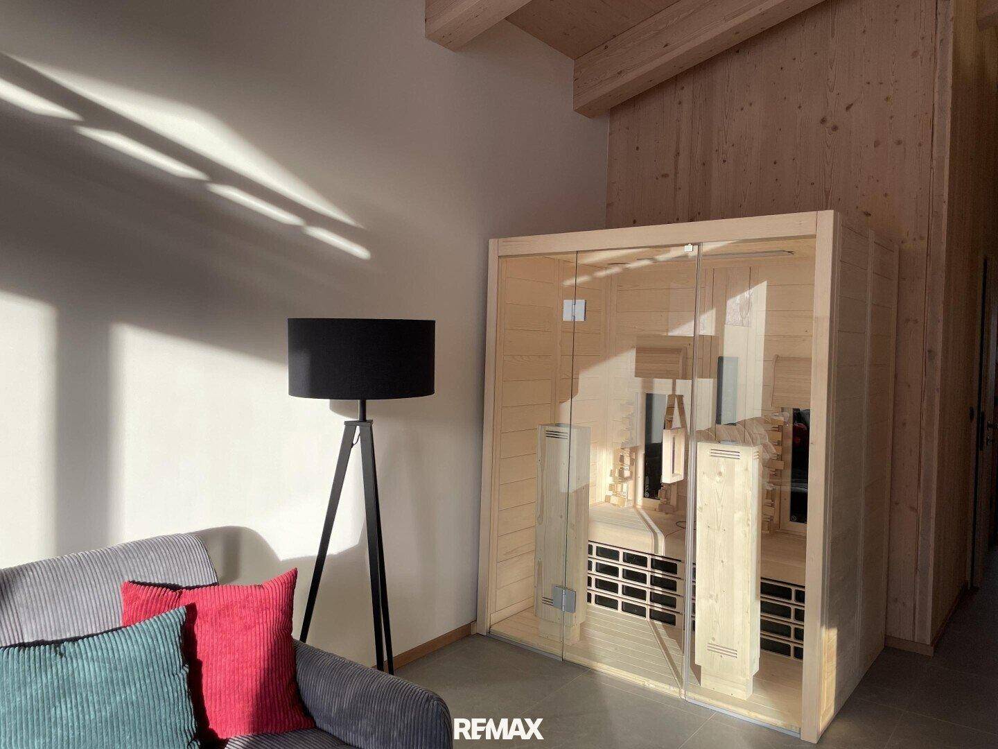Moderne Sauna mit Glasfront und Holzbänken, integriert in den Wohnbereich.