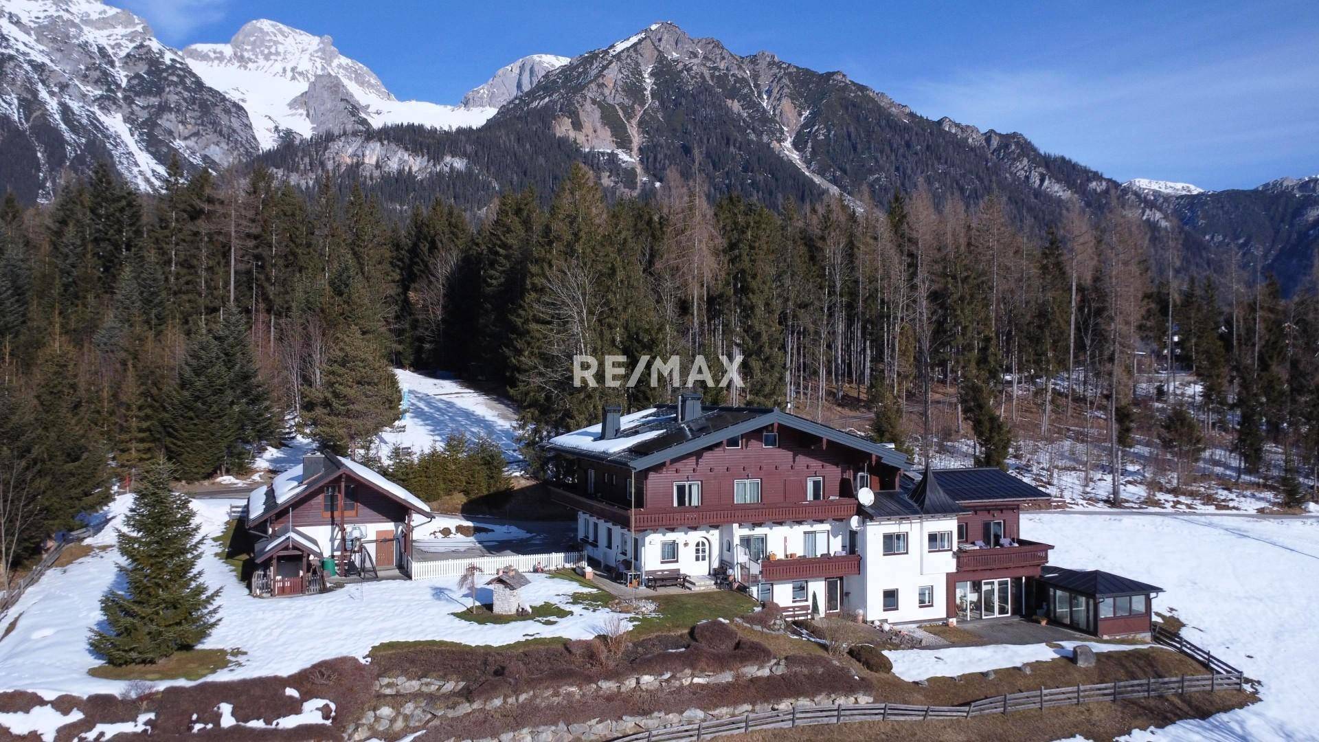 Panoramablick auf das große Anwesen mit mehreren Gebäuden, eingebettet in eine malerische Winterlandschaft.