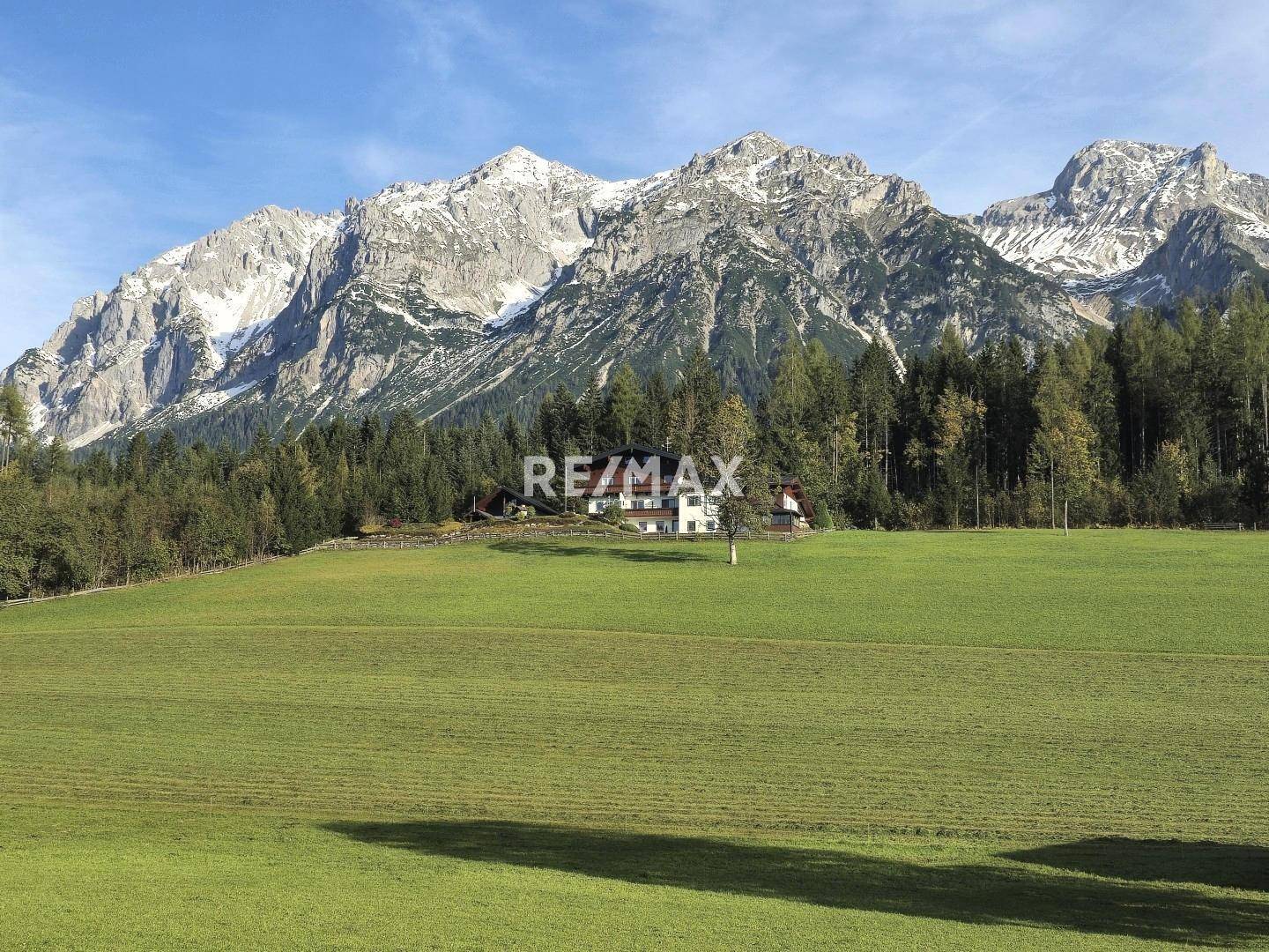 Weitläufiges Anwesen in idyllischer grüner Alpenlandschaft mit majestätischem Bergblick.
