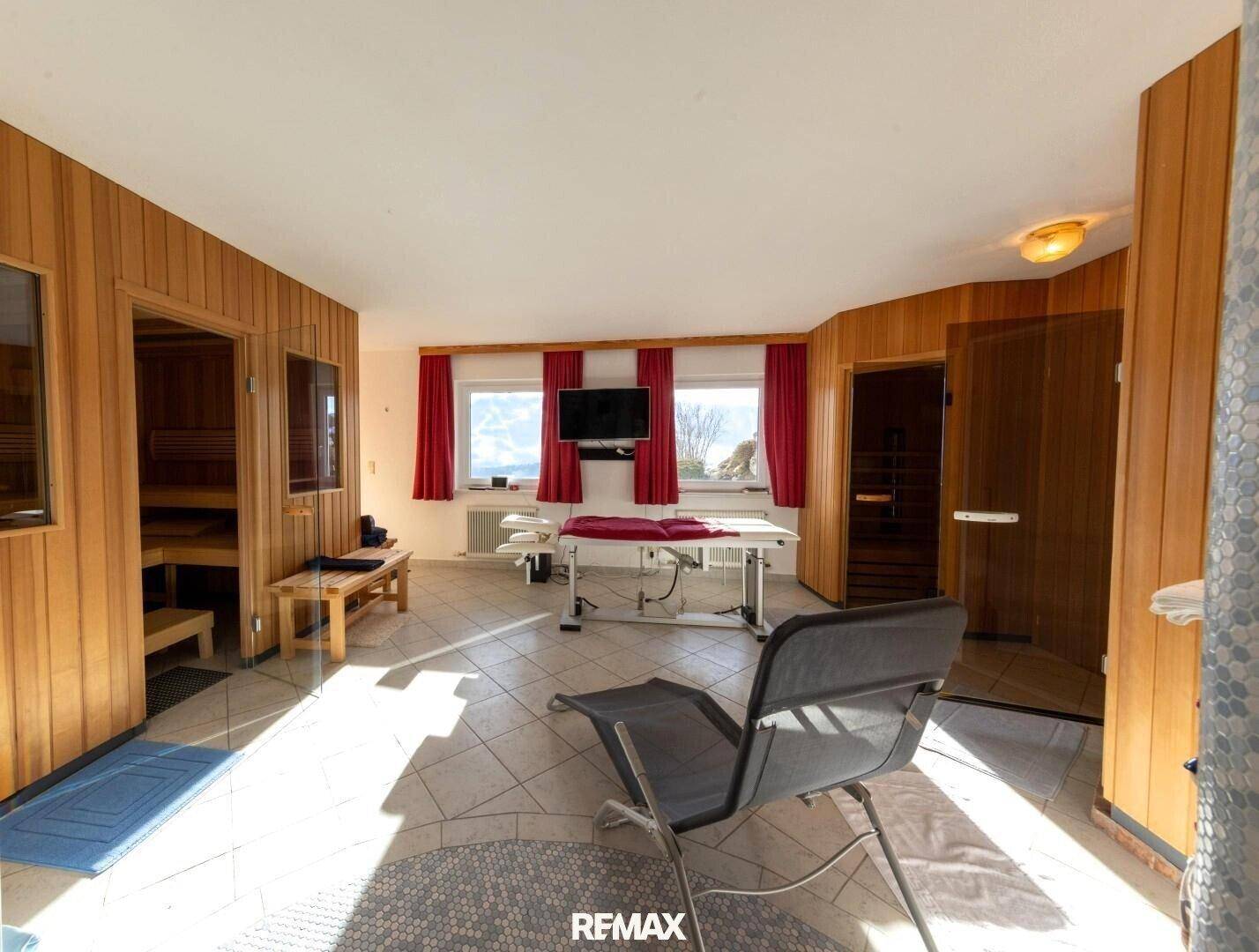 Heller Wellnessbereich mit Holzsaunen, Massageliege und Entspannungssessel, ideal zur Erholung.