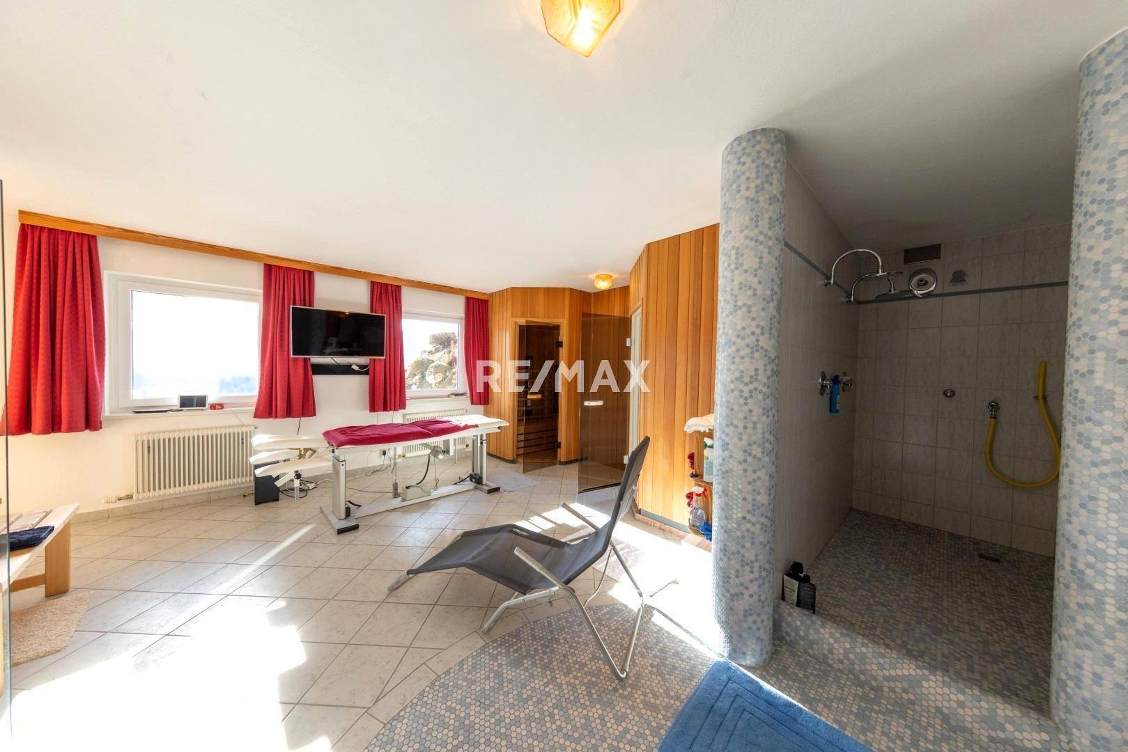 Heller Wellnessbereich mit Sauna, Mosaikdusche und Liegefläche, bietet Entspannung und Komfort.