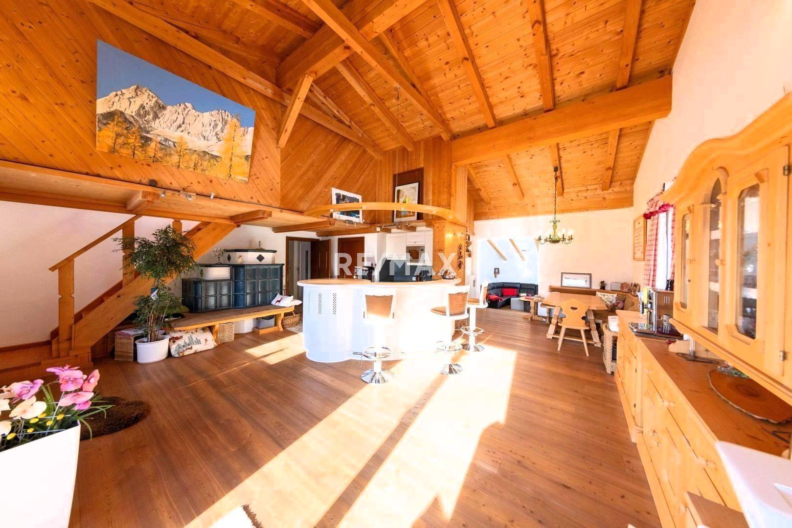 Großzügiger offener Wohnbereich mit Holzbalkendecke, Bar und Essbereich, lichtdurchflutet.