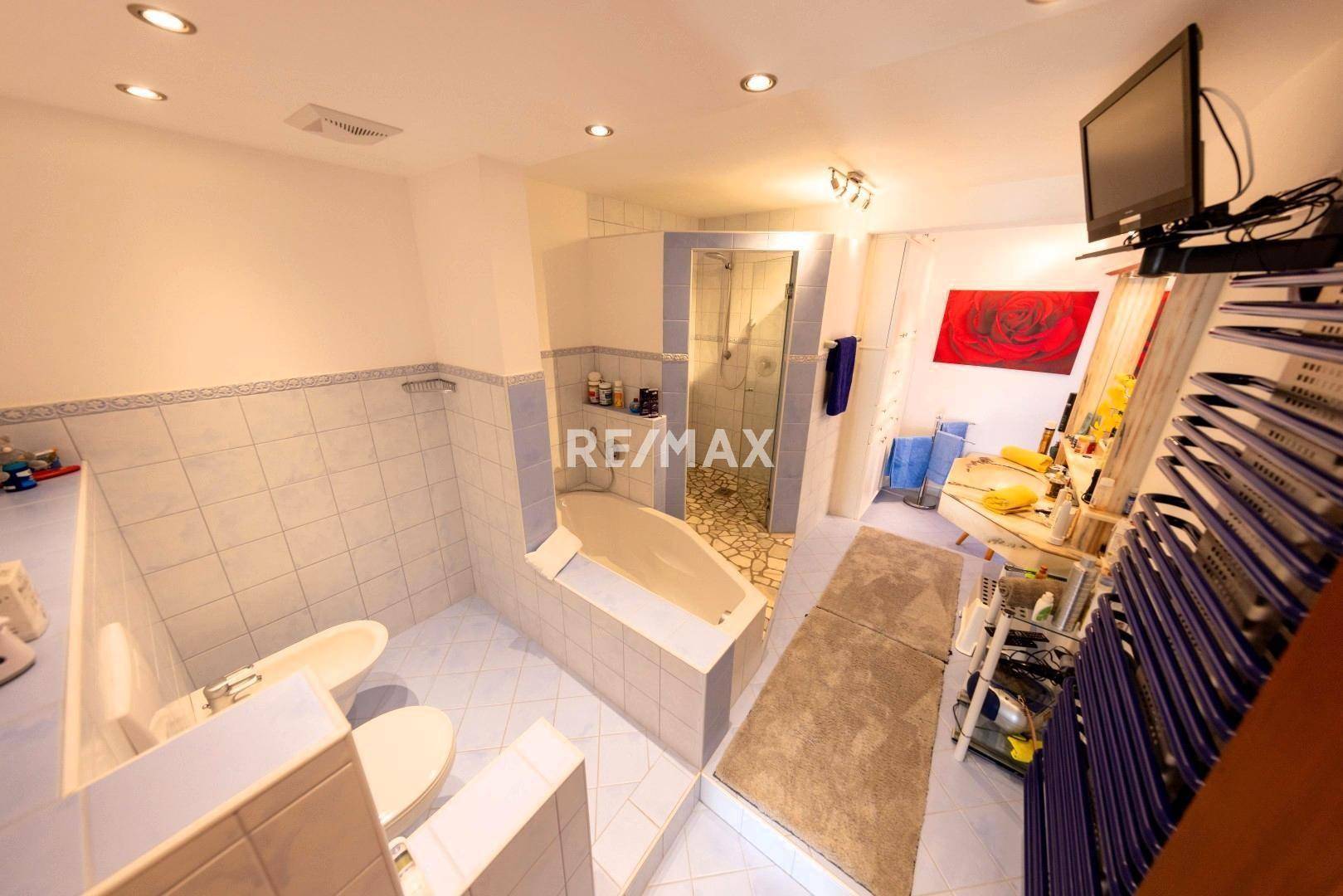 Großes Badezimmer mit Dusche, Badewanne, Bidet und hellblauen Fliesen im 80er-Jahre-Stil.