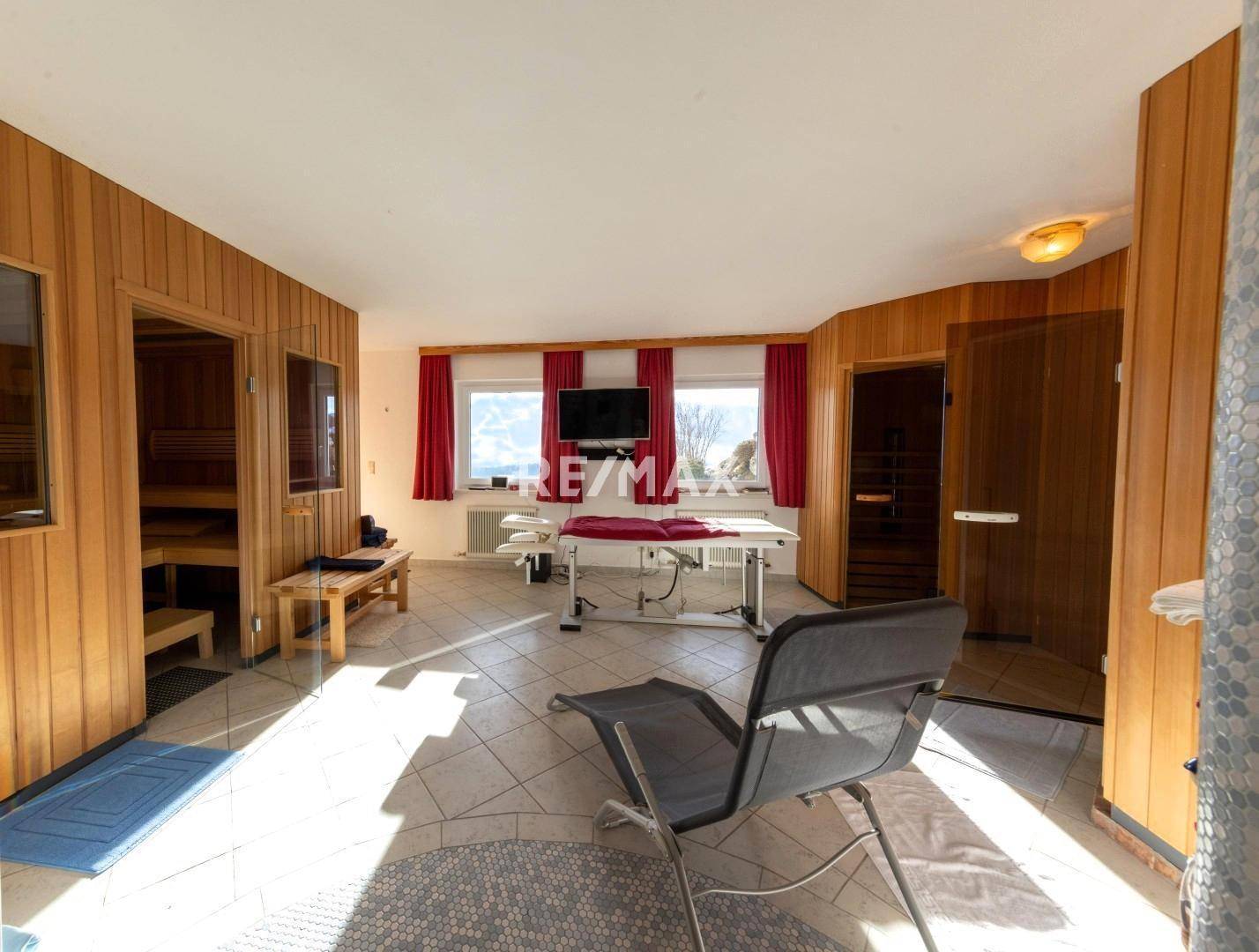 Geräumiger Wellnessbereich mit Sauna, Duschen und Liegemöglichkeiten, ideal zur Entspannung.