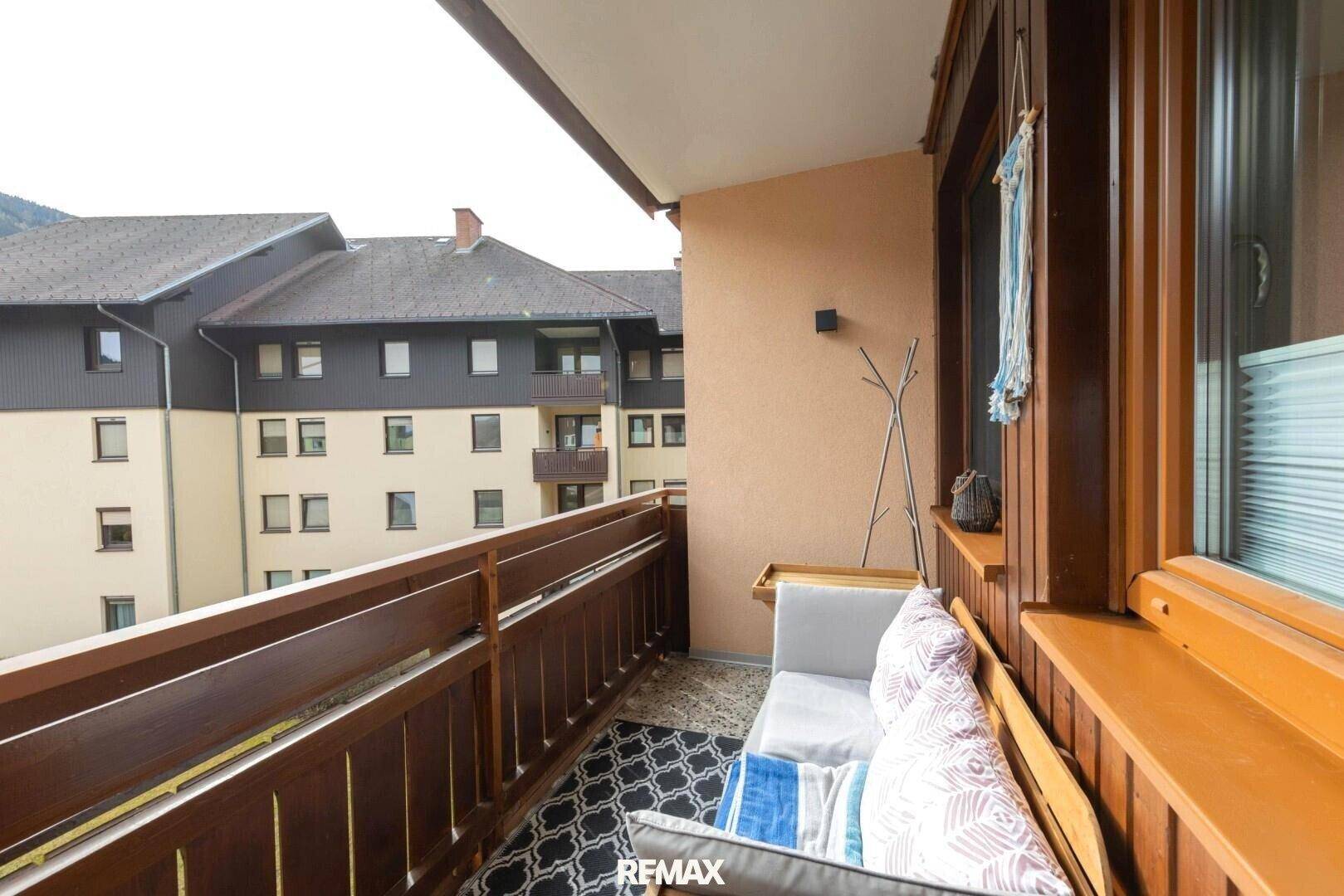 Balkon mit Holzelementen und Blick auf die umliegenden Gebäude.