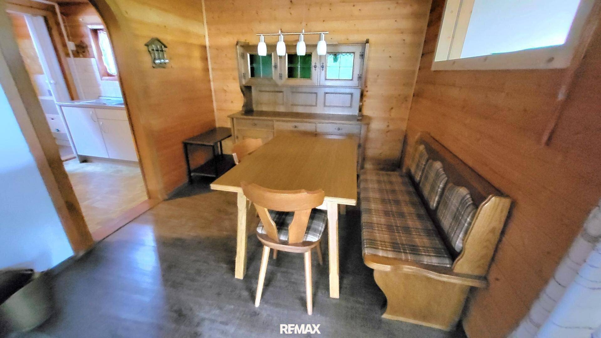 Gemütlicher Essbereich mit Holztisch, Eckbank und traditionellem Buffet.