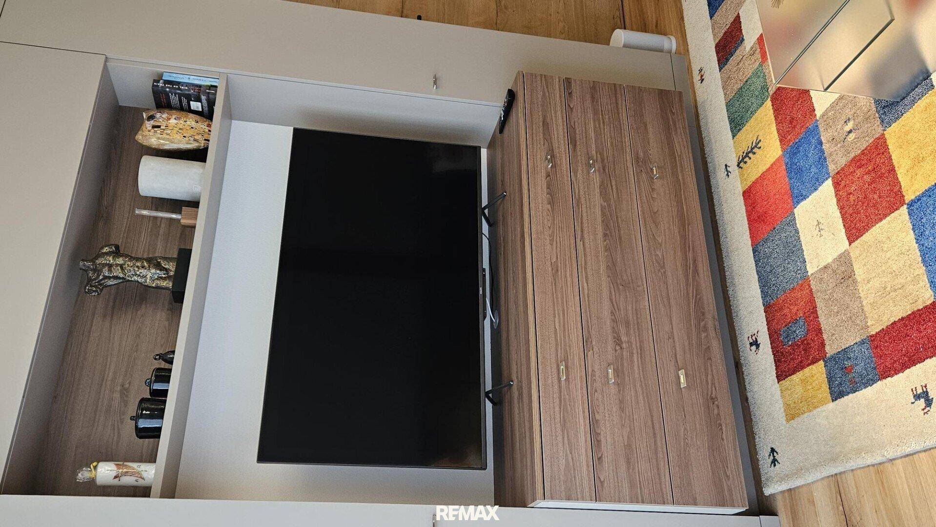 Integrierter Medienschrank mit Fernseher, Regalen und Holzfronten im Wohnbereich, praktisch und platzsparend.