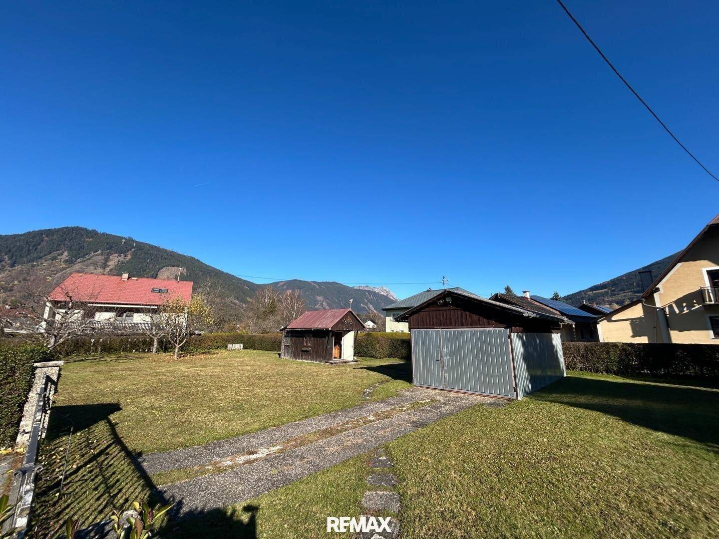 Weitläufiger Gartenbereich mit Schuppen und freiem Blick auf die Bergkette.