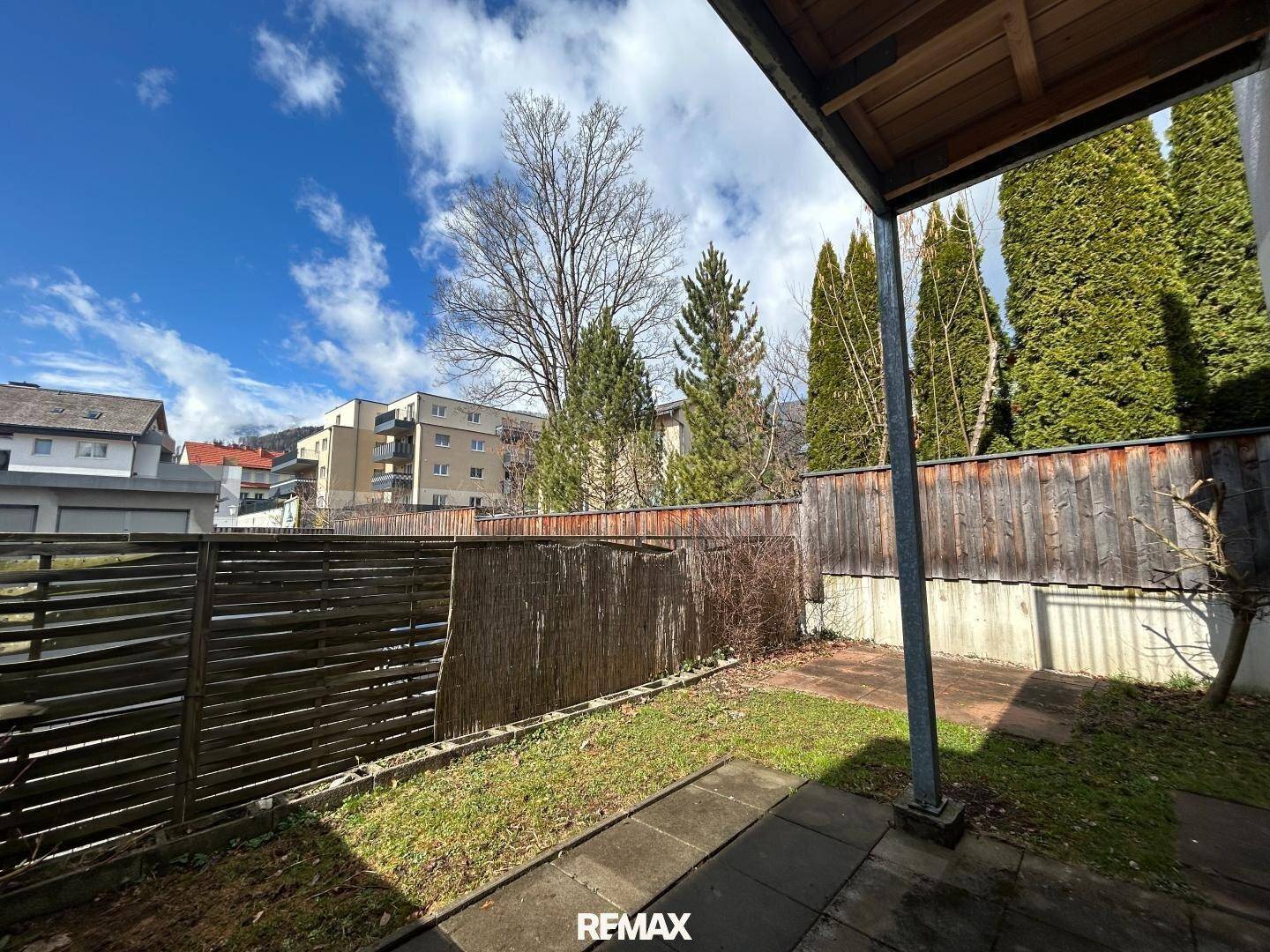 Gartenbereich mit Terrasse und Blick auf die umliegende Wohnbebauung.
