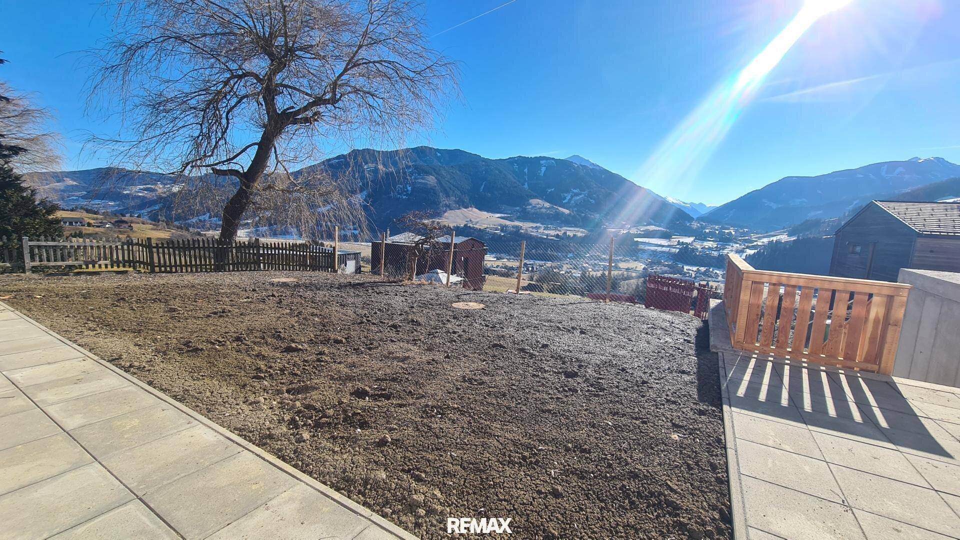 Sonniges Grundstück mit Bergblick, vorbereitetem Gartenbereich und angrenzender Terrasse.