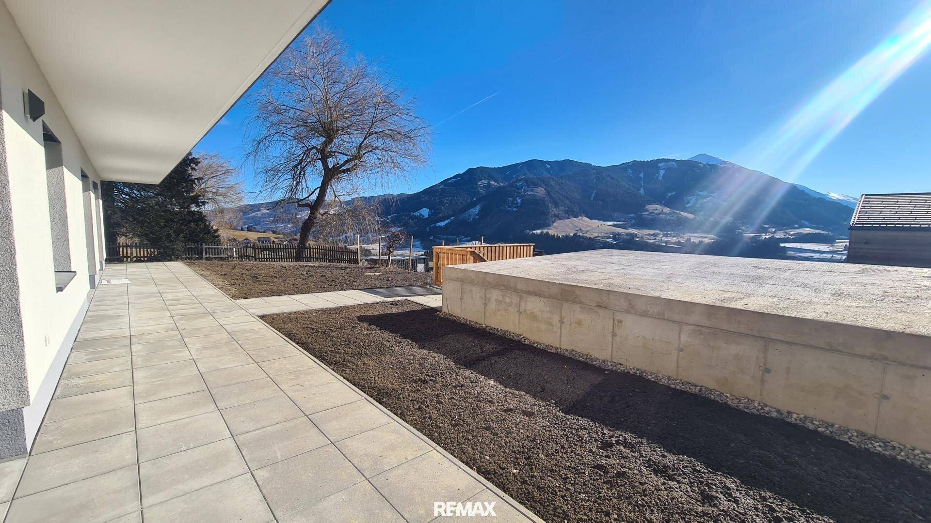 Geräumige Terrasse mit Blick auf die Berge und angrenzendem Gartenbereich.