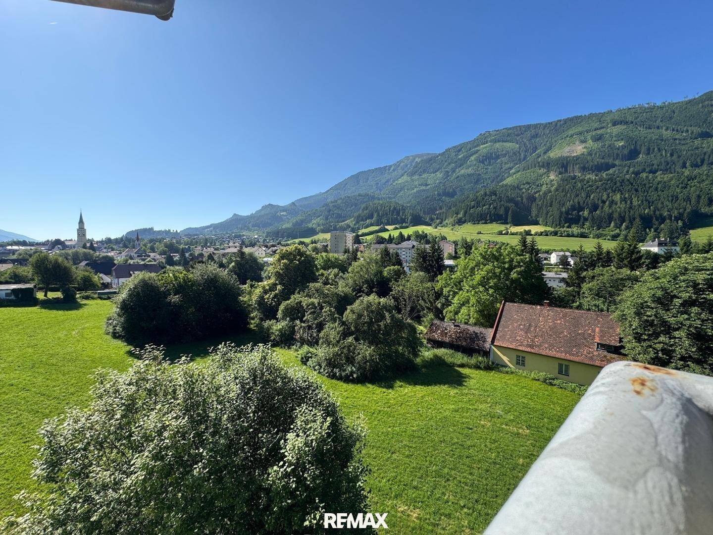 Weitläufiger Blick auf grüne Hügel, Berge und eine ländliche Umgebung.