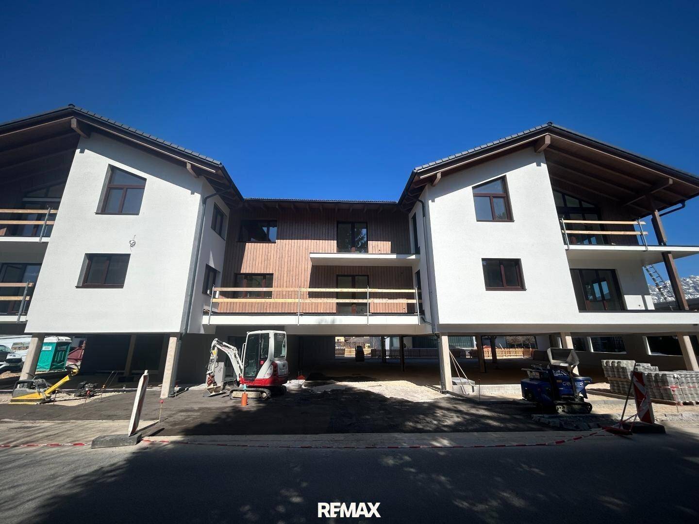 Neubau mit moderner Architektur, Holzverkleidung und Balkonen in sonniger Lage.
