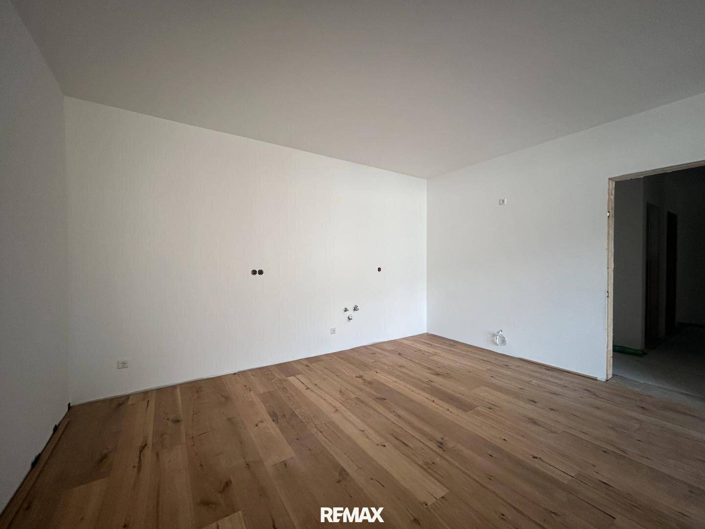 Unmöbliertes Zimmer mit hellem Parkettboden und weißen Wänden, bereit zum Einzug.