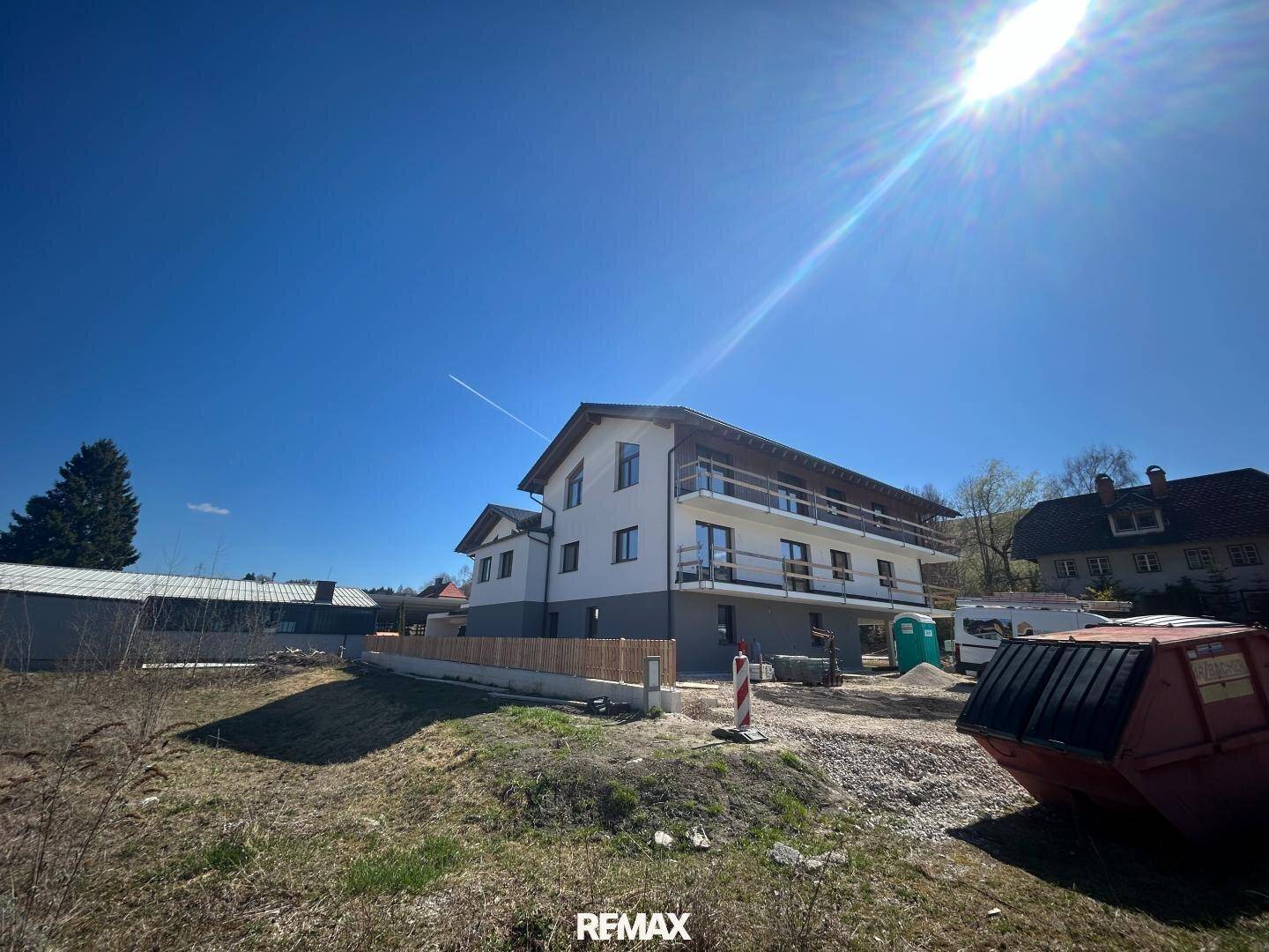 Neubau in sonniger Umgebung mit Balkonen und Blick auf die umliegende Landschaft.