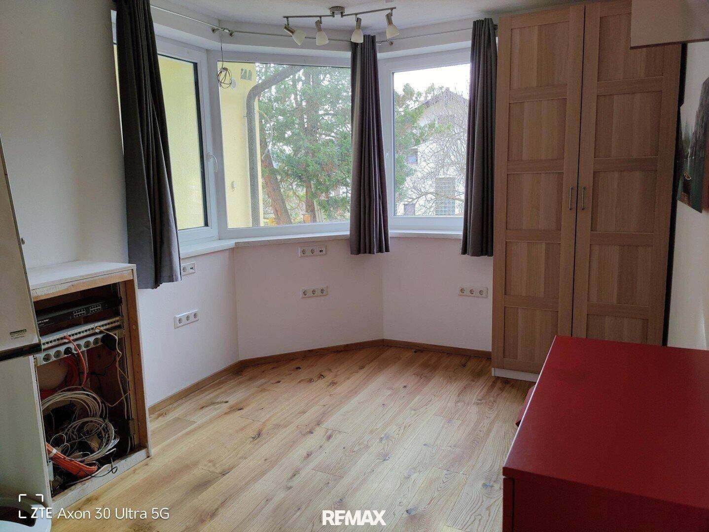 Raum mit Holzboden, Erkerfenster und Einbauschrank, ideal als Büro oder kleines Schlafzimmer.