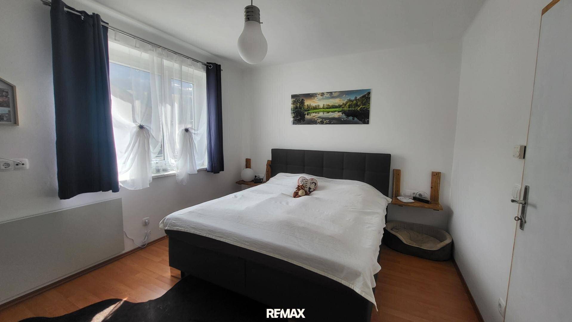 Helles Schlafzimmer mit großem Bett und Fenster, ideal für erholsame Nächte.