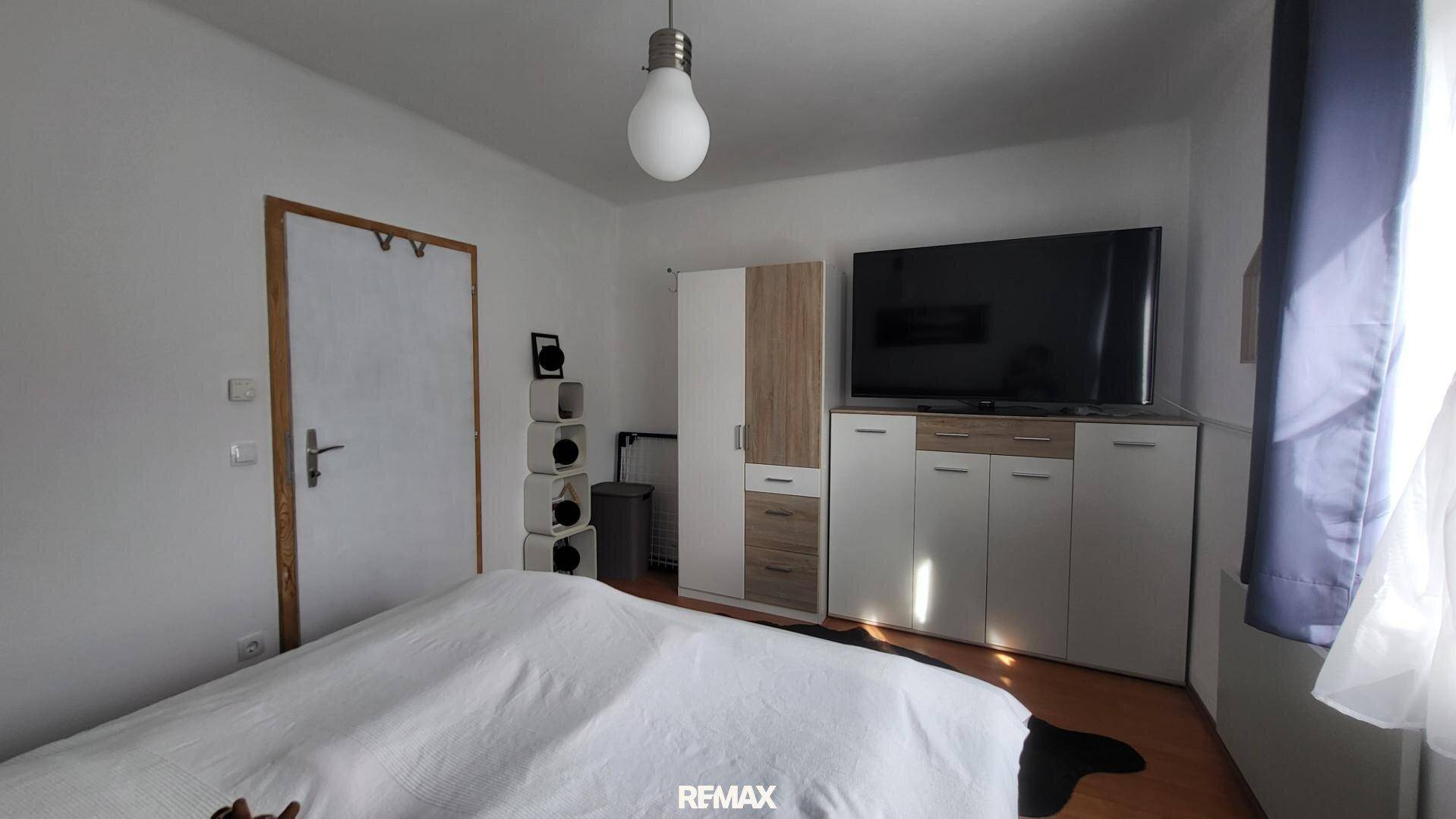 Schlafzimmer mit Kleiderschrank und Fernseher, bietet praktischen Stauraum und Unterhaltung.