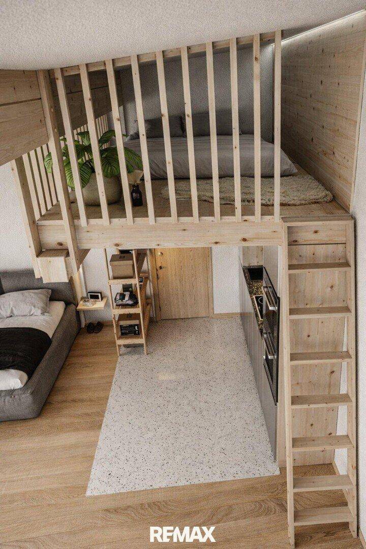 Offener Wohnbereich mit Holztreppe zum Schlaf-Loft und integrierter Küchenzeile.