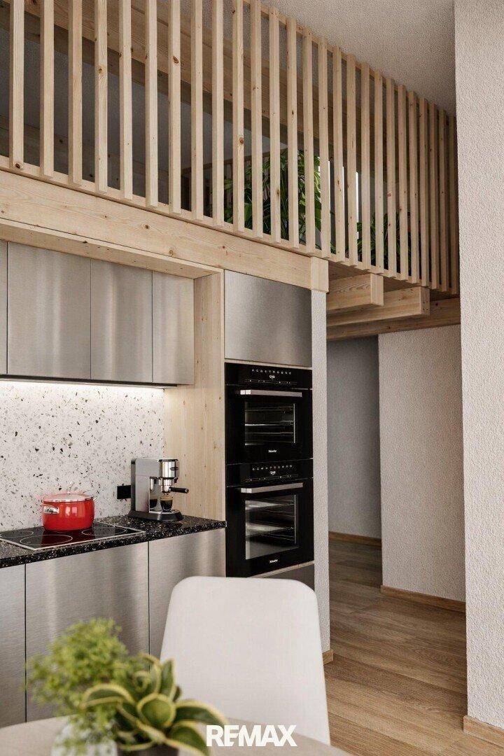Moderne Küche mit Edelstahloberflächen und integrierten Geräten unter einem Holz-Loft.