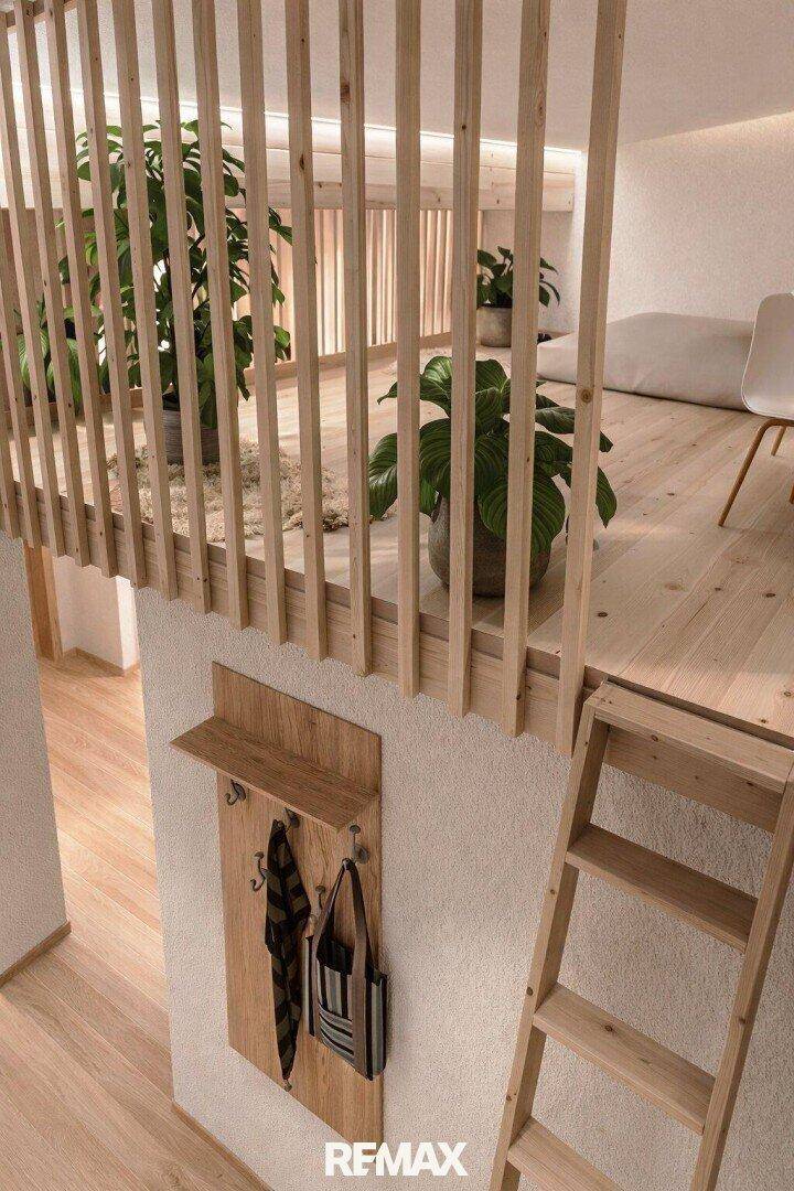 Detailansicht des Loftzugangs mit Holzleiter und Garderobe in einem hellen Innenraum.