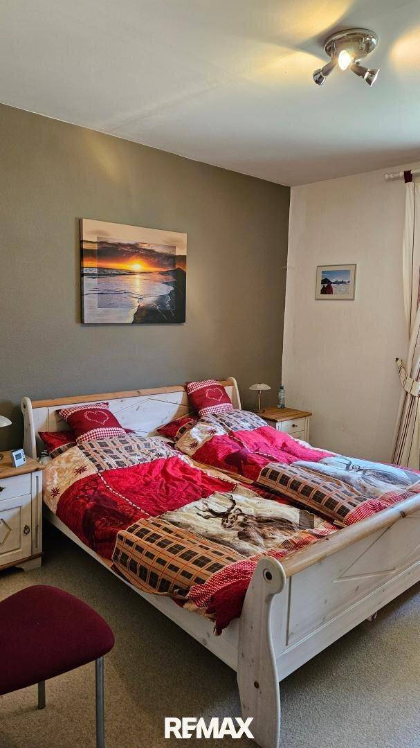 Gemütliches Schlafzimmer mit Doppelbett und traditioneller Bettwäsche, einladend gestaltet.