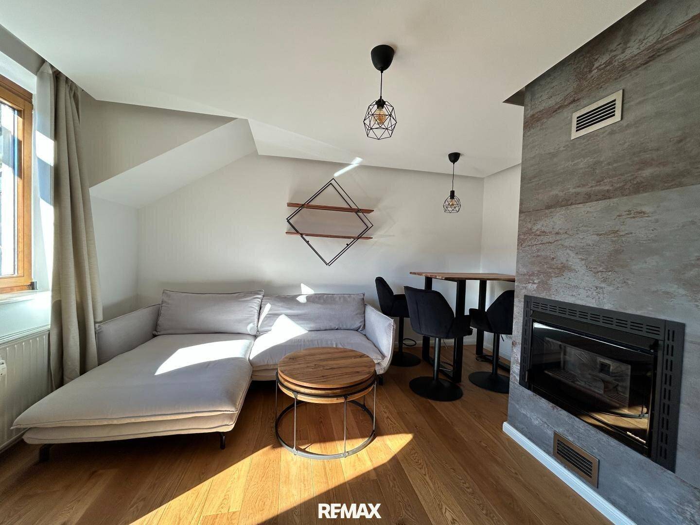 Gemütlicher Wohn-Essbereich mit Kamin, bequemer Couch und modernem Interieur.