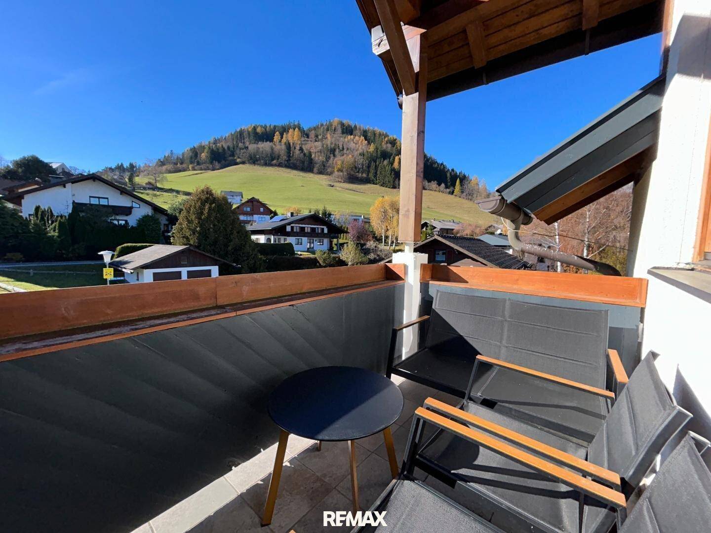 Gemütlicher Balkon mit Sitzgelegenheiten und Blick auf die umliegende Hügellandschaft.