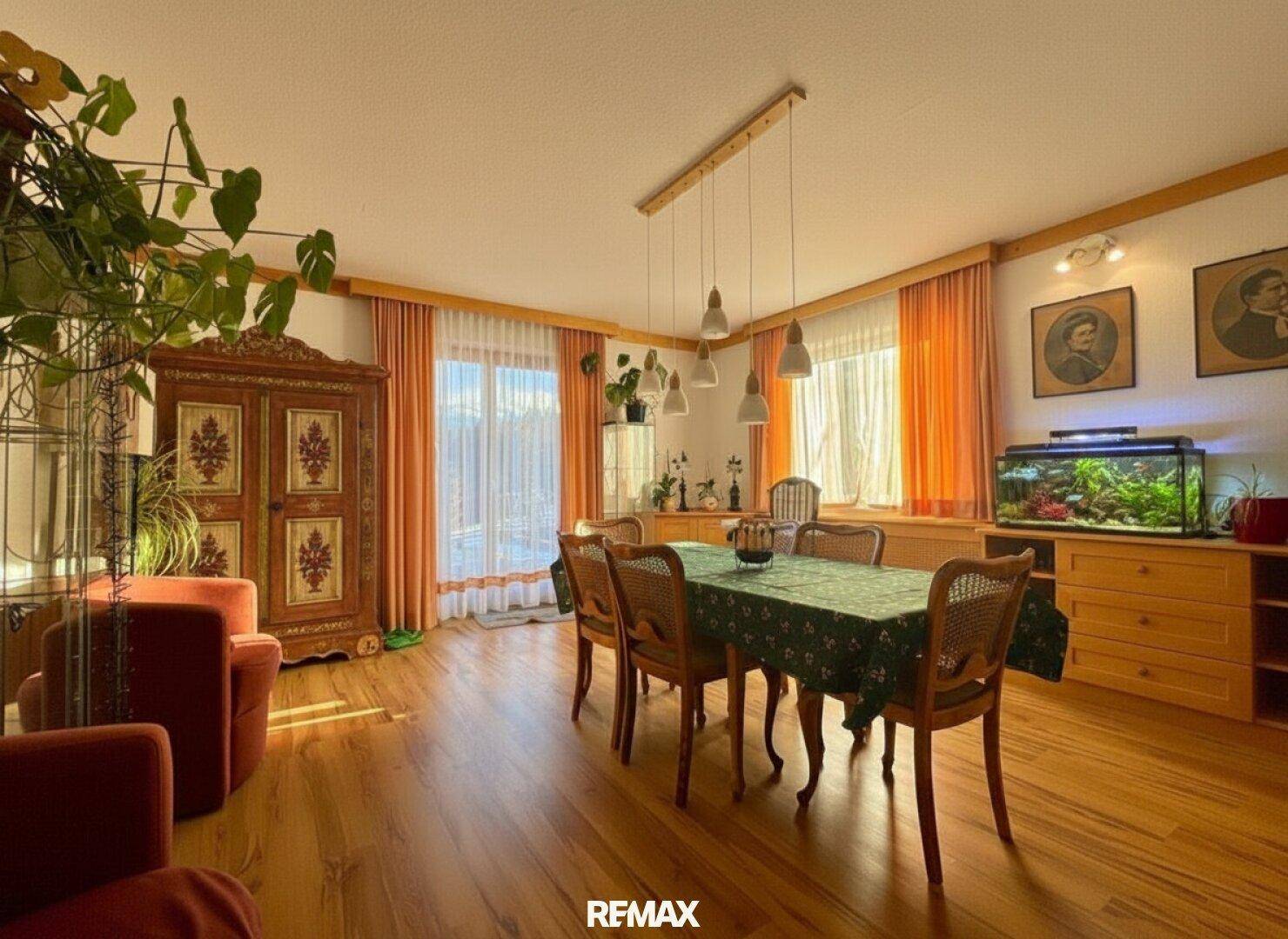 Geräumiges Esszimmer mit großem Holztisch, traditionellen Möbeln und Aquarium.