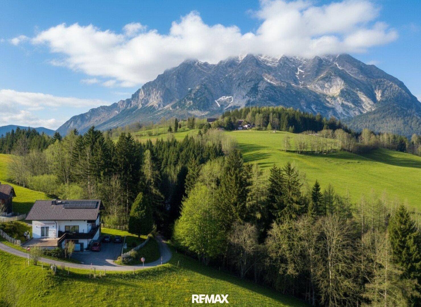 Haus in idyllischer Lage mit beeindruckendem Bergblick und umgeben von grünen Wäldern.