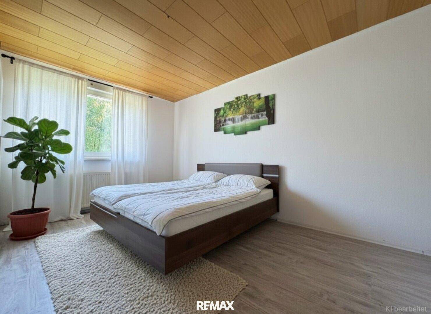 Schlafzimmer mit Doppelbett, Holzboden und einer markanten Holzpaneeldecke.